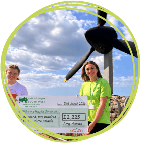 Two young women at a charity cheque presentation